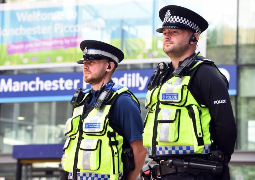 Two British Transport Police officers stand at Manchester Piccadilly