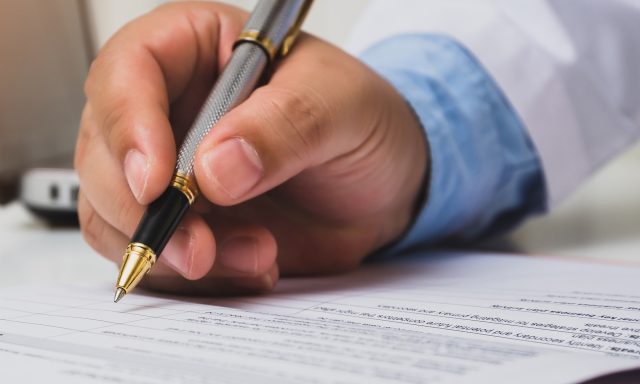 Doctor using a pen to write medical notes