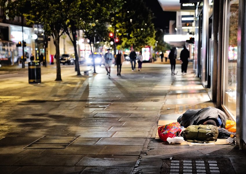 Scene of Oxford Street, London, at night with homeless person sleeping on pavement