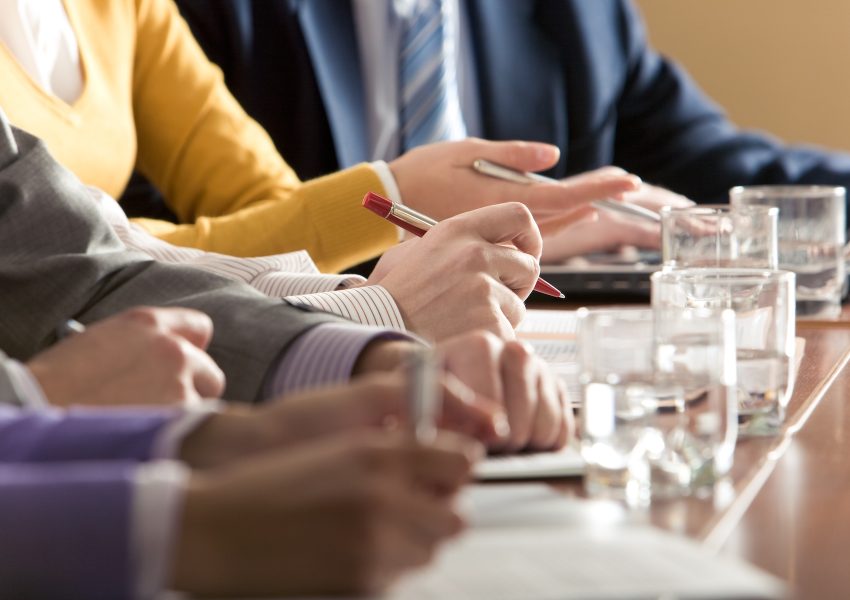Members of board meeting discuss agenda items