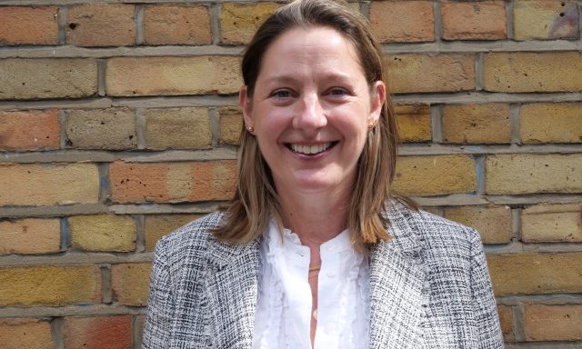 Dr Debbie Martin, mental health law lead within the Thalamos Responsible Innovation Group, photographed against a brick wall.