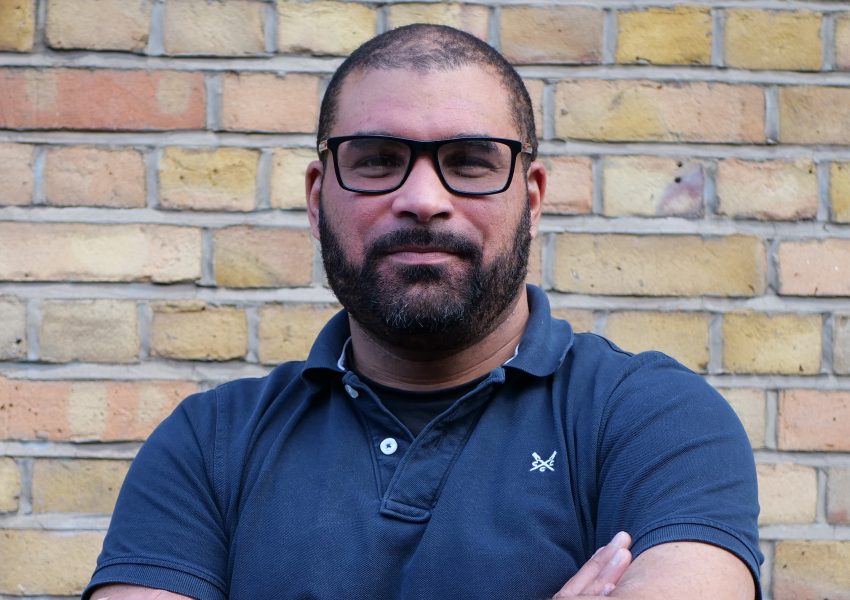 Steve Gilbert OBE, lived experience lead within the Thalamos Responsible Innovation Group, photographed against a brick wall.